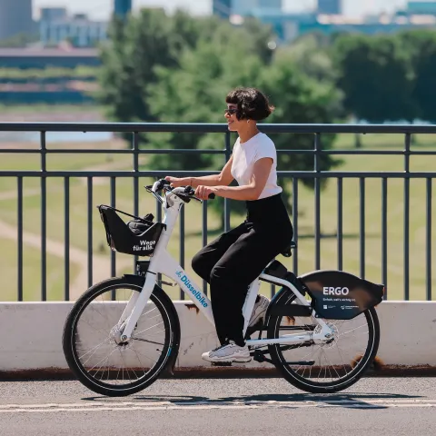 Zwei Personen auf der Oberkasseler Brücke fahren mit dem Düsselbike