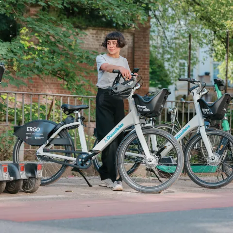 Frau an einer Sharingstation mit dem Düsselbike